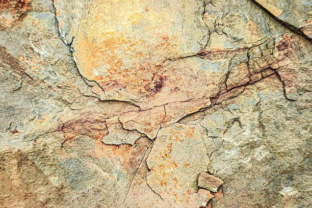 istock Textured rock surface displaying various hues and patterns under natural light, captured in an outdoor setting during daytime 2246498336