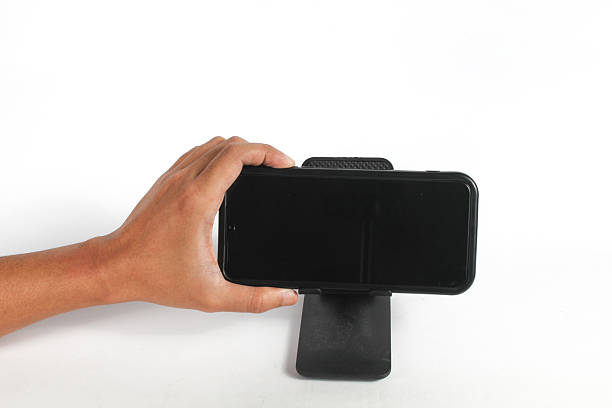 istock hand pressing the loudspeaker button on the cell phone attached to the holder 2246498387