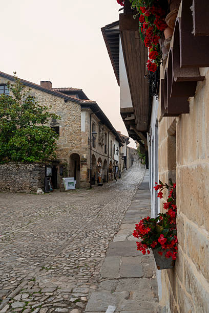 istock A street with a brick wall and a window with red flowers. 2246499232