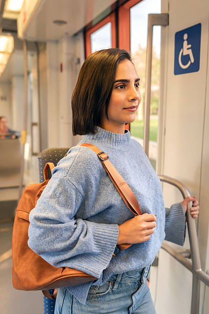 istock Young woman with backpack traveling on public transport train 2246499306