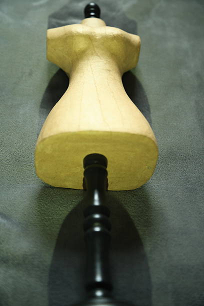 Studio session of a small cardboard mannequin on a wooden leg