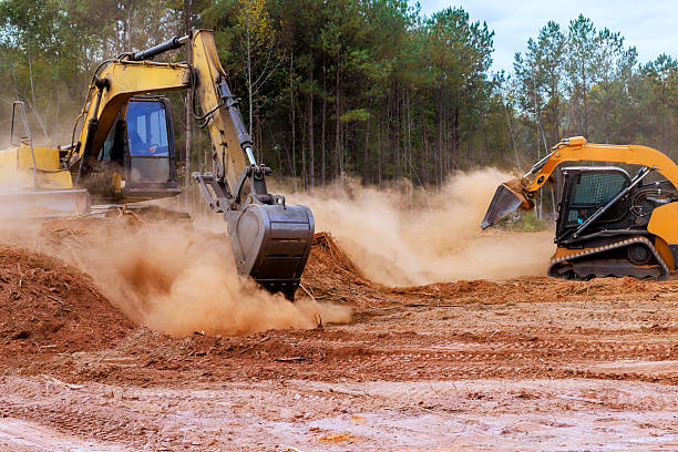 istock Heavy machinery works on construction site, moving dirt clearing land for new development 2246512845