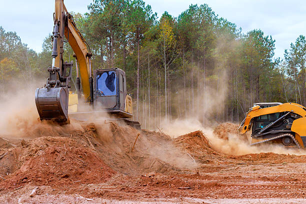 istock Heavy machinery clears land in forested area for construction work as dust clouds rise into air 2246512851