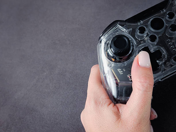 istock close up of a hand holding a transparent video game controller on a dark gray background 2246516897