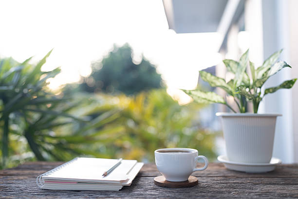 istock White coffee cup and notebook, potted plant arranged on rustic wooden table 2246518643