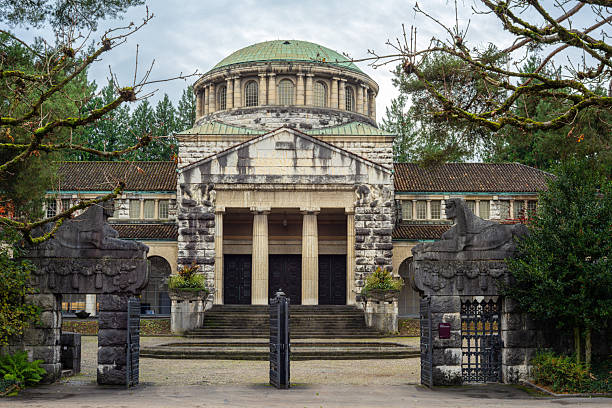 Zurich, Switzerland - November 1, 2025: Historic Old crematorium at Sihlfeld cemetery in Zurich, with a domed roof and stone columns, surrounded by trees.