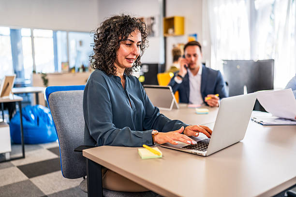 istock Mid adult woman smiling while working in office 2246519232