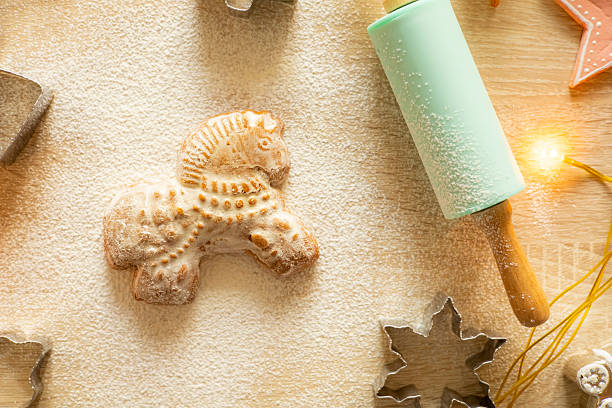 A horse-shaped gingerbread on a table with flour and a rolling pin. Baking Christmas cookies. High quality photo