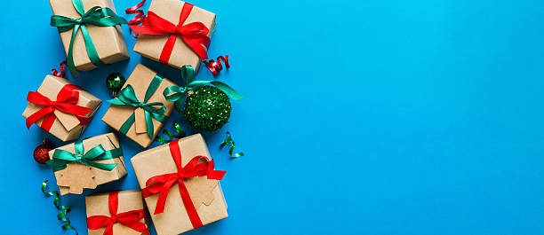 istock wrapped christmas or other holiday handmade present in paper with colored ribbon. Present box, decoration of gift on colourfull table, top view with copy space 2246522449