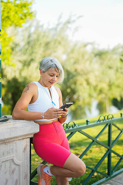 istock Active woman taking a break and using her smartphone outdoors 2246524958