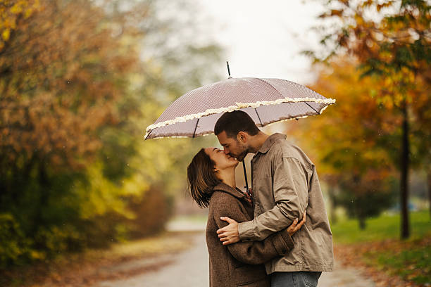 istock Young couple kissing under umbrella during autumn rain 2246528196