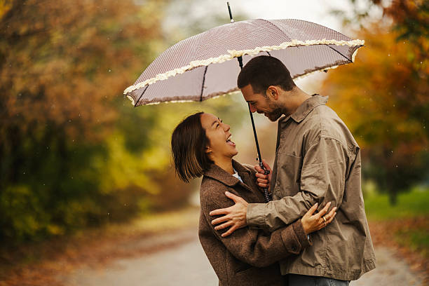 istock Couple laughing under umbrella in autumn rain 2246528197