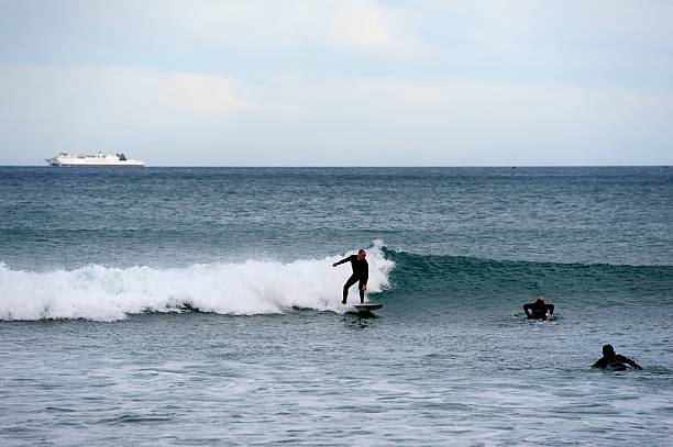 Lyall Bay, Wellington, New Zealand - 18th August 2025:Surfers riding a big wave in Lyall beach