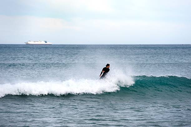 Lyall Bay, Wellington, New Zealand - 18th August 2025:Surfers riding a big wave in Lyall beach