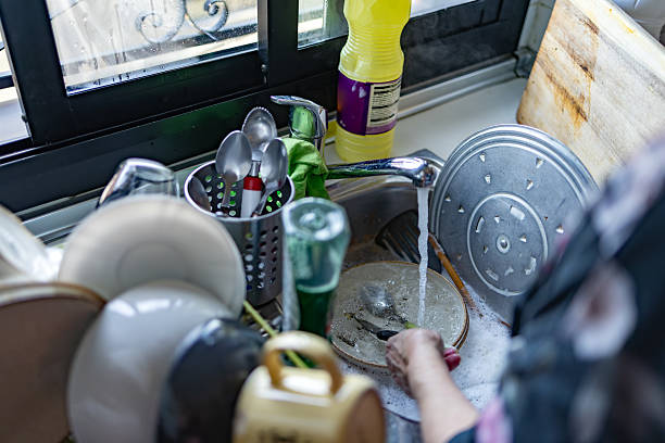 istock Person washing dishes, cleaning kitchen sink 2246529812