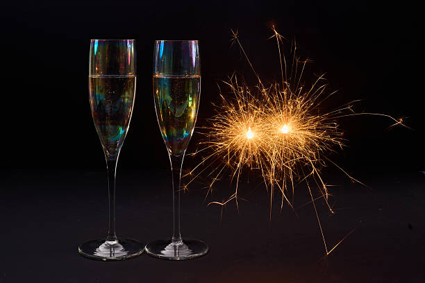 istock Sparkling Celebration. Two champagne glasses with bright sparklers against a dark background 2246530555