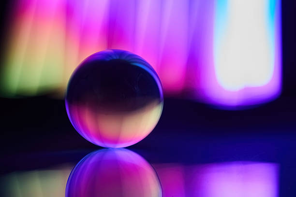 istock Vibrant Light Sphere. A glass sphere placed on a reflective surface with colorful light 2246530763