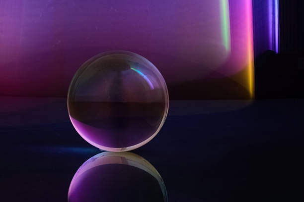istock Luminous Sphere Reflection. A glass sphere reflecting colorful ambient light in a dark 2246530802