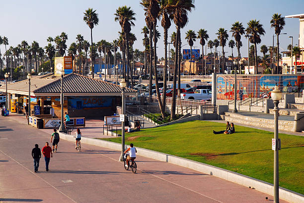Huntington Beach, CA, USA September 25 People walk and bike on the beach front promenade boardwalk of Huntington Beach, California on a sunny summer vacation day