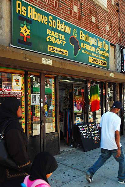 Brooklyn, NY, USA May 30 A woman in traditional Muslim dress passes an independent store specializing in African style crafts and gifts catering to the community