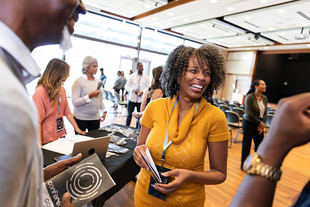 istock Diverse group of people smiling and conversing at an indoor conference event 2246532707