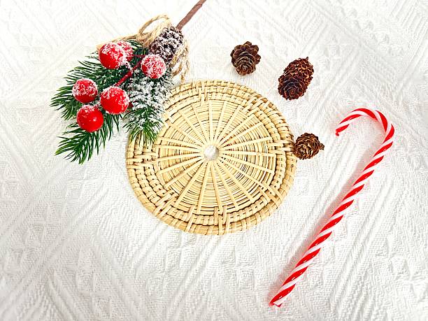Festive Christmas Arrangement with Pinecones, Candy Cane, and Decorative Spray on Soft White Background, Perfect for Holiday-Themed Displays and Designs