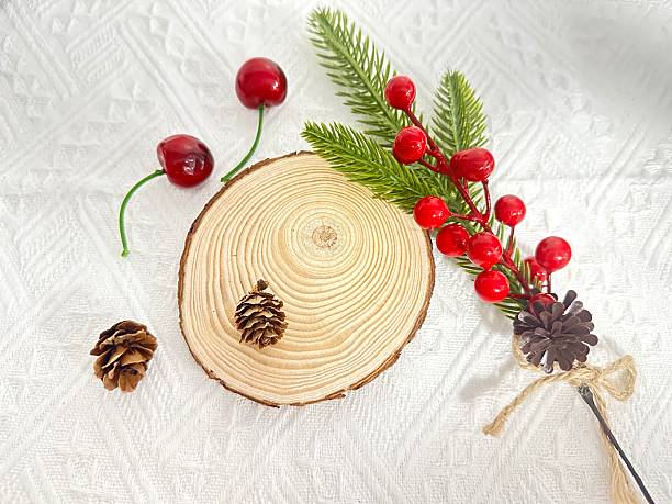 Christmas Decor Elements with Wooden Slice, Pine Cones, Berries, and Greenery on Textured Background for Holiday Season Crafts and Decorations