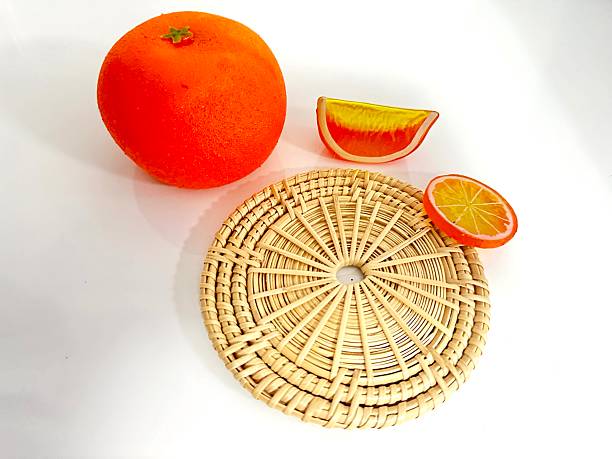 istock Orange Fruit and Slices with Handmade Woven Mat in Bright Colors on White Background for Culinary and Decorative Use 2246535500