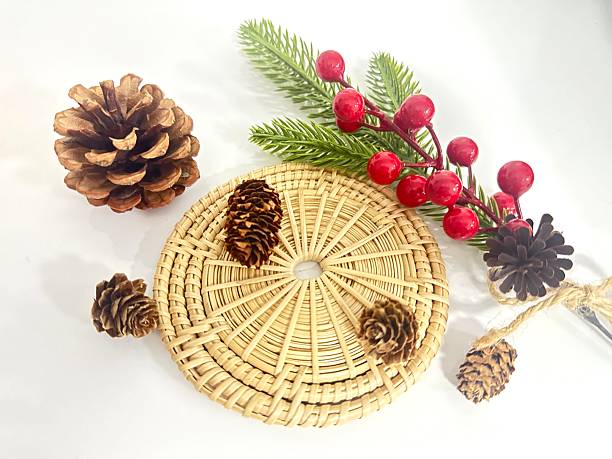 istock Natural elements with pine cones, red berries, and woven mat showcasing a cozy autumn or winter vibe for seasonal decor or craft projects 2246536490