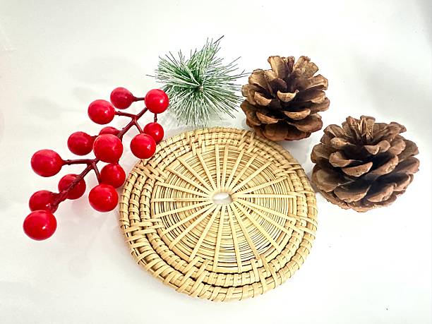 istock Natural Elements with Christmas Decor Featuring Pine Cones, Holly Berries, and a Straw Mat for Seasonal Festivities 2246536514
