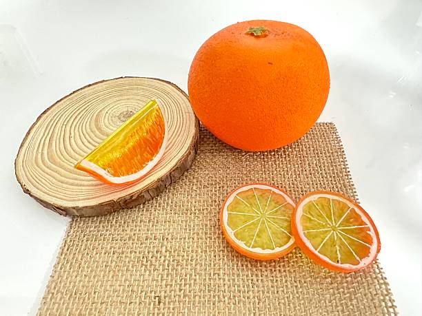 istock Fresh and Vibrant Orange Fruit Display with Slices on Rustic Wood Background Perfect for Culinary and Health-Themed Projects 2246536727