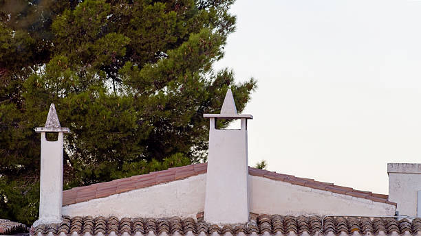 Amidst cloudy weather, witness the overcast emission from the flue atop the roof, blending with the stormy atmosphere.
