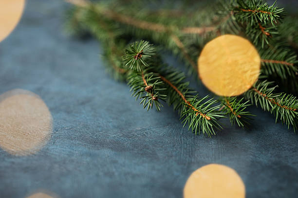 istock Fir branches and Christmas lights with a bokeh effect on a dark blue background 2246540357