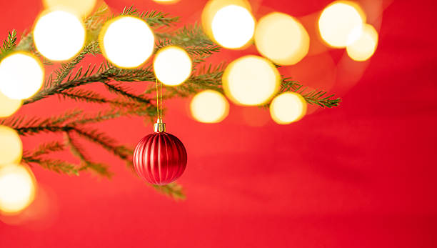 istock Fir tree branches with a Christmas tree ornament with a bokeh effect from the garland 2246540590