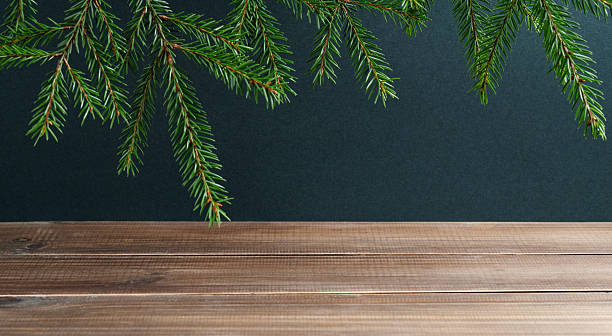 istock Fir branches on a dark green and wooden background. 2246540705