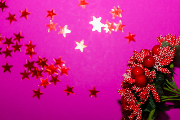 This vibrant, celebratory shot features red decorative stars twinkling against a bold magenta/fuchsia background, creating a playful and out-of-focus texture.