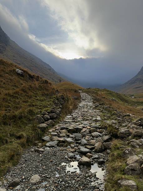 A hiking trail passes up the valley outside of Seathwaite in the Lake District on a moody autumn day