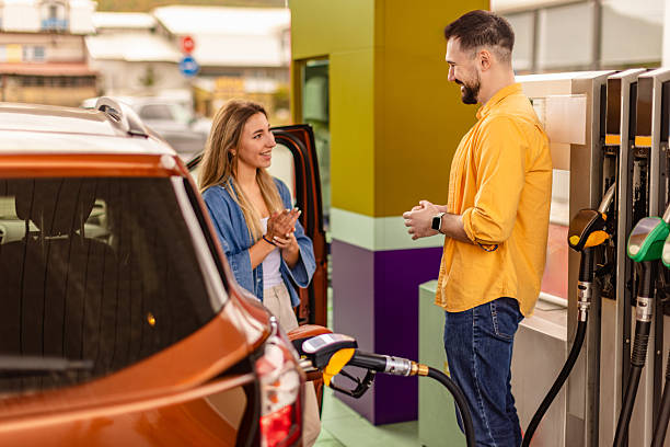 istock Couple interacting at a modern gas station while refueling a vehicle on a sunny afternoon 2246545351