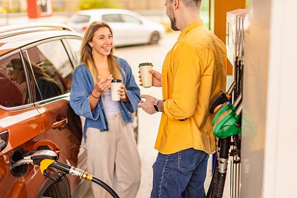 istock Two people enjoying conversation while refueling their vehicle at a gas station on a sunny day 2246546192