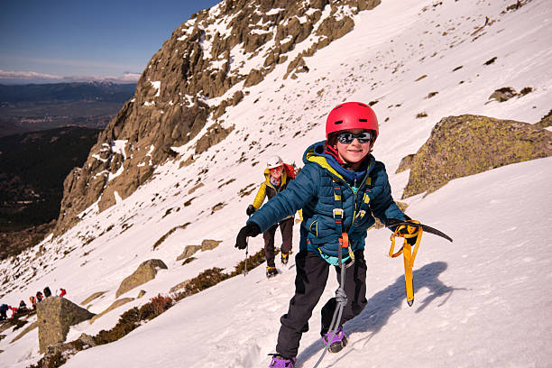 Portrait of a happy child in the mountains with his parents, enjoying mountain activities
