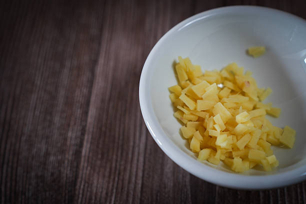 Freshly chopped ginger pieces in a moody ambient lighting. Suitable for food, editorial, medical , health and culinary use