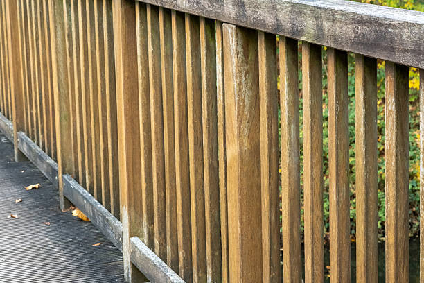 Weathered wooden bridge railing providing safety along an outdoor path