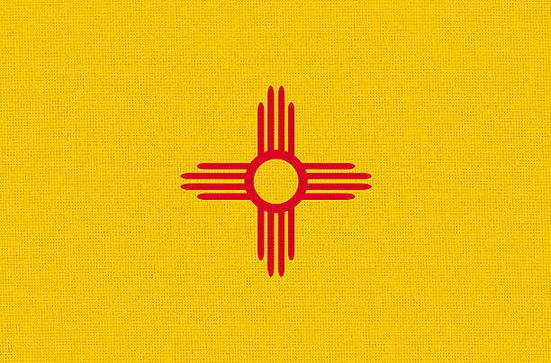 American state New Mexico flag on fabric surface. New Mexico state flag on textured background. Colored New Mexico flag on fabric surface. Official American state symbol