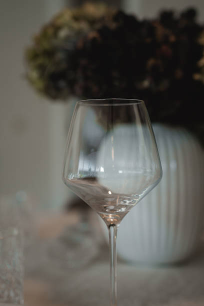 istock A clear, empty modern wine glass standing elegantly on a table, ready for a special occasion amidst a subtly blurred, sophisticated setting. 2246552863