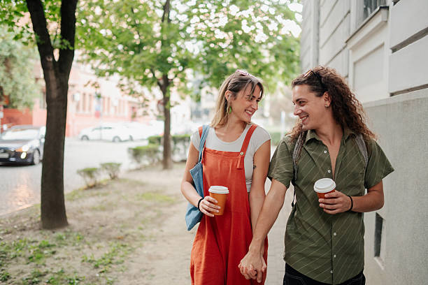 istock Happy couple walking holding hands and drinking coffee 2246553102