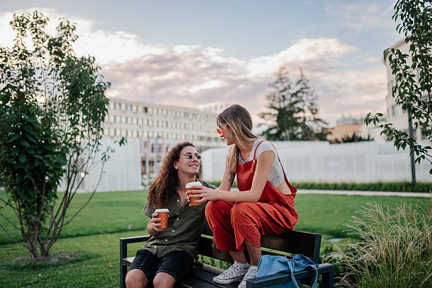 istock Young couple enjoying coffee while sitting in urban park 2246553108