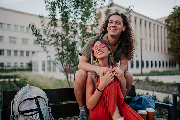 istock Young couple enjoying outdoor leisure time on a bench 2246553126