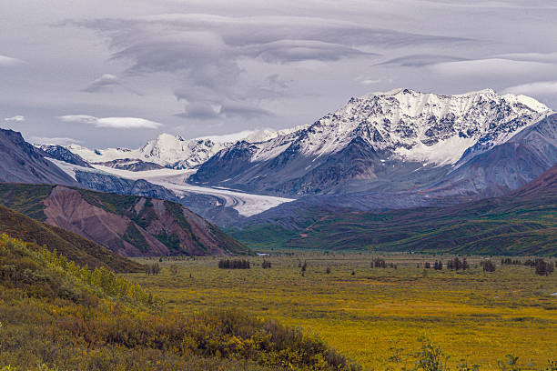 The vast Gulkana Glacier carves through the Alaskan mountains under a dramatic sky.