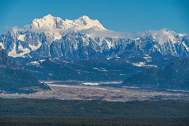 istock Snowy mountains, glacier, and forest under a blue sky. 2246556068