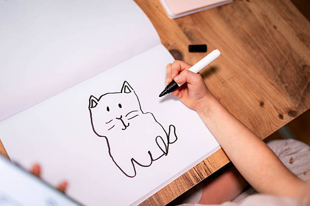 A five-year-old girl’s sketch of a cat on paper, showing spontaneous lines and the unique charm of children’s artwork.